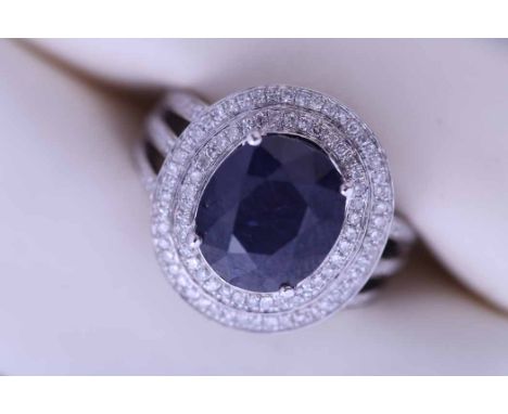 SAPPHIRE AND DIAMOND CLUSTER RING
the central oval cut sapphire approximately 5.6 carats, surrounded by two rows of brilliant