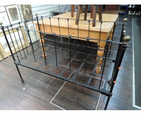 A vintage black painted cot having brass ball finials, decorative use only