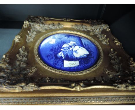 A famed ceramic blue and white transfer printed tile with gilt effect frame