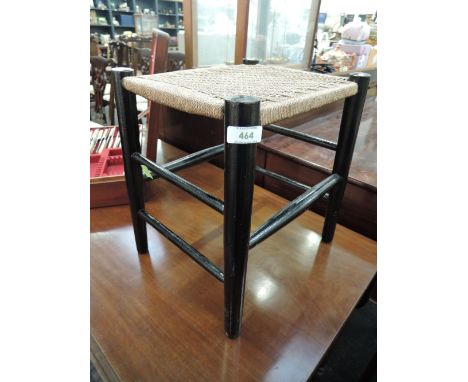 A vintage strung stool having ebonised frame