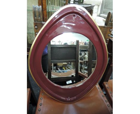 A ceramic framed eye shaped mirror with art deco design and burgundy finish 