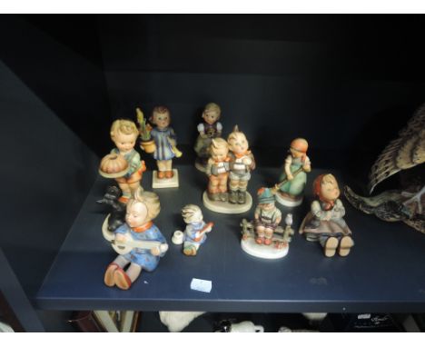 Nine Hummel figurines including boy with pumpkin pie and dog, girl playing banjo etc (some af) 