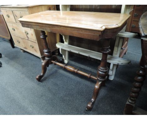 A 19th century walnut and mahogany card table having swivel top on turned legs, cross stretcher and splay supports
