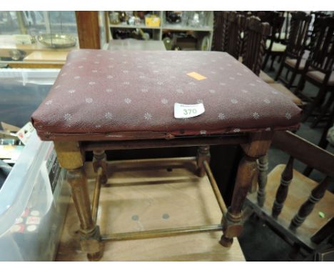 A vintage foot stool with turned legs and vinyl top