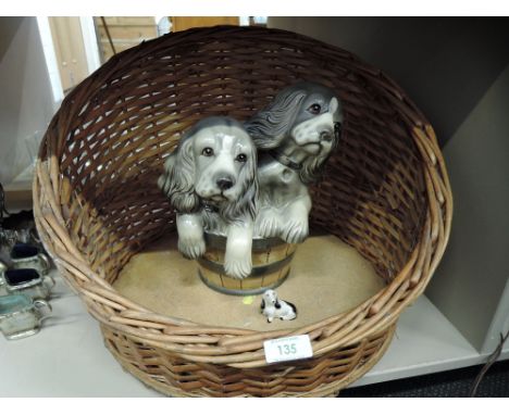 A wicker woven dog or cat basket with ceramic Spaniel dogs in bucket figure