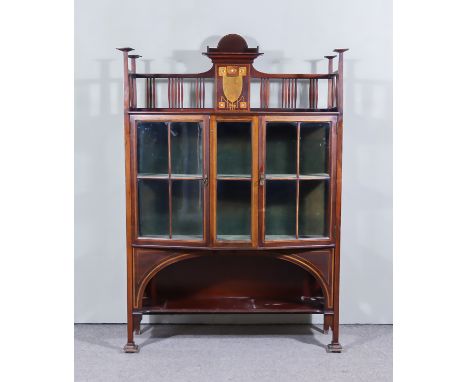 An Edwardian Mahogany Display Cabinet of "Art Nouveau" Design, inlaid with stylised leaves and chequered stringings, the gall