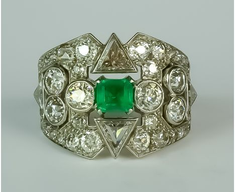 An Emerald and Diamond Cluster Ring, Early 20th Century, in white coloured metal mount, set with a centre faceted emerald, ap