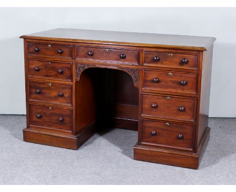 A Victorian Mahogany Kneehole Desk, stamped W. Williamson of Guildford, the later top with moulded edge, fitted nine drawers,