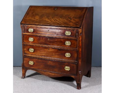 A George III Mahogany Bureau, the slope enclosing pigeon holes, central cupboard and four small drawers, four long graduated 