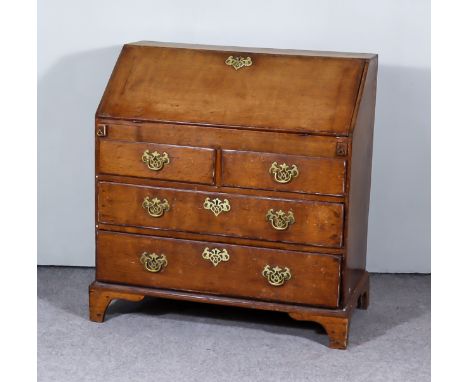 A George III Oak Bureau, the slope enclosing stepped interior, fitted four small drawers and pigeon holes, two short and two 