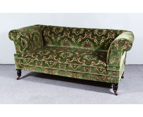 A Victorian Three Seat Drop End Settee with scroll ends, upholstered in leaf pattern moquette, on turned legs and castors, 68