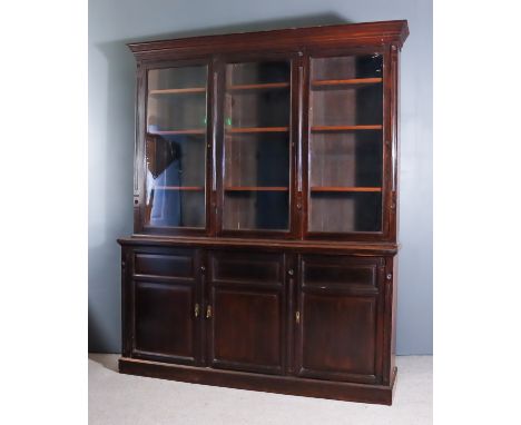 A Late Victorian Dark Walnut Bookcase, the upper part with moulded cornice, fitted nine adjustable shelves enclosed by three 