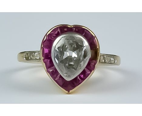 A Diamond and Ruby Heart Shaped Ring, Early 20th Century, yellow metal set with a centre pear shaped diamond, approximately .