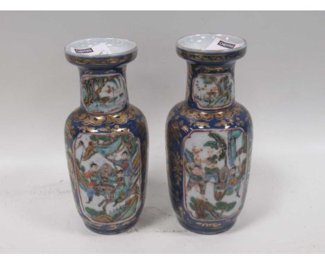 A pair of small Chinese vases of baluster form, the reserves with fighting warriors set in a dark blue ground with overgildin