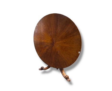 An early Victorian rosewood breakfast table, the circular tilt top, on a faceted baluster column and leaf carved tripod suppo