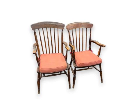 A near pair of 19th century and later beech and elm comb back armchairs, with loose red seat cushions on turned legs97cm and 