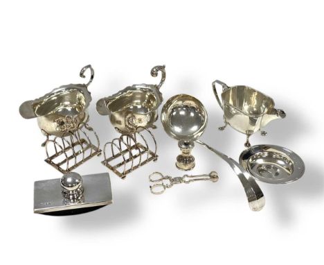 A collection of silverware including sauce boats, cream jug, ladle, armada dish, miniature pepper mill, toast racks, blotter,