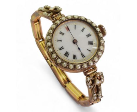 A ladies 9ct gold vintage watch with decorative dial and pearl set bezel and shoulders, case made by Saunders &amp; Shepherd,