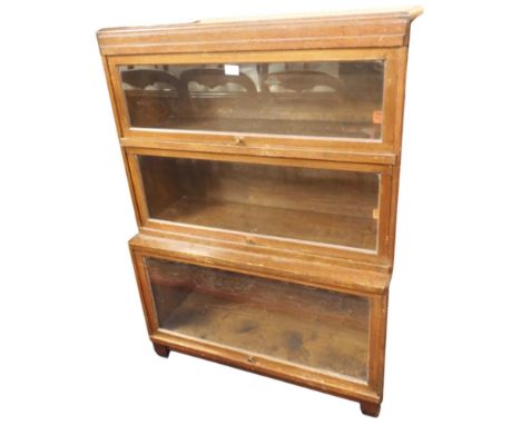 An early 20th century oak Globe Wernicke sectional bookcase with three glazed fall front doors on square footed base, 115cm h