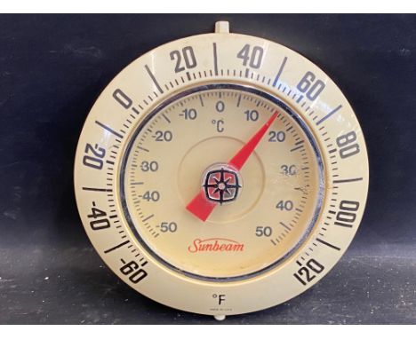A small circular plastic wall mounted thermometer with Sunbeam branding to the dial.