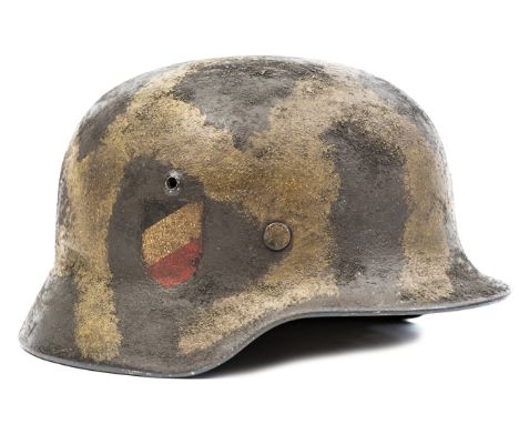 A Third Reich M35 double decal steel helmet,  the skull with camouflage painted textured finish and painted over army eagle a