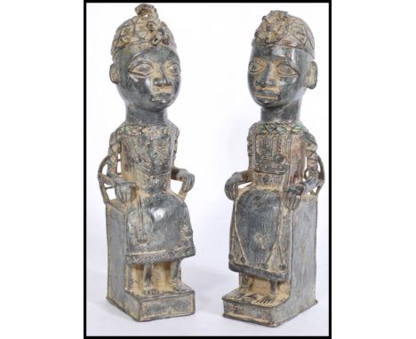 A pair of large unusual cast bronze African tribal statue / figurines. Each of seated religious men with costume and dress.&n