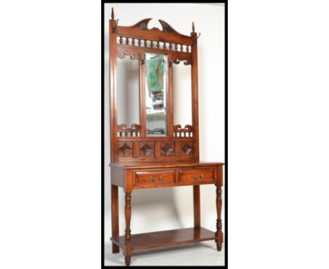 A Victorian style hardwood hall stand with upright mirror back having glove drawer to the centre and stick stand base. Measur