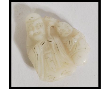 A 19th century Chinese carved white jade figurine group depicting an elder and child.&nbsp;measures: 4.5cm high x 3.5cm wide.