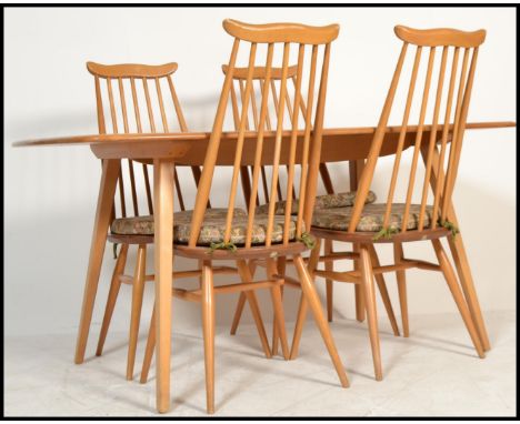 Ercol - A vintage 20th century blonde beech and elm wood refectory plank dining table being raised on shaped supports united 