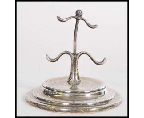 A silver hallmarked ring stand tree with 4 wavey arms over terraced base being hallmarked for Birmingham by W H Haseler, 1911
