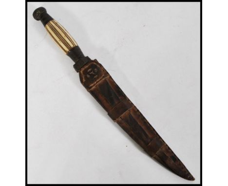 A 19th century bone handles bronze dagger complete in leather hide sheaf.