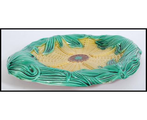 A 19th century Victorian Majolica ceramic bread board plate depicting corn in a woven basket.&nbsp;Measures 34cm-wide.&nbsp;