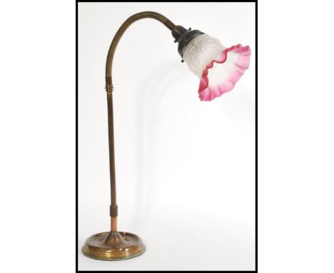 A 20th century Art Deco style goose neck desk lamp on a round base with a cranberry and frosted glass shade with a handkerchi