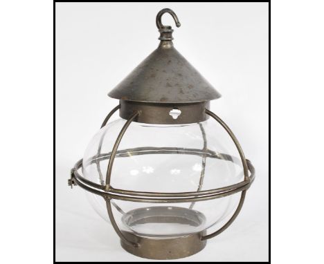 A vintage 20th Century Georgian revival porch lantern, the glass shade of bulbous form with a metal work cage to the outside,