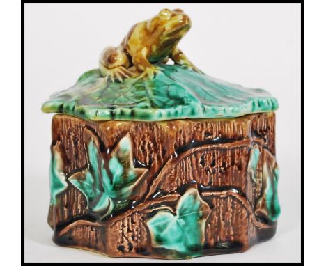 A 19th century Victorian Majolica pot in the form of a log with leaf and vine decoration having a figural frog finial lid wit