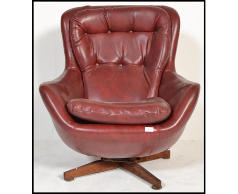 An original 1960's retro vintage button back swivel egg type chair, raised on a four point splayed teak support.&nbsp;Measure