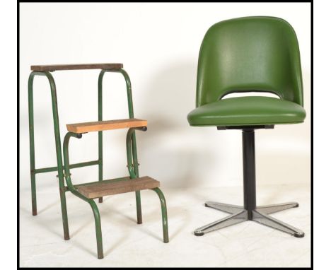 A vintage 20th century retro green leather bucket seat spinning raised on a metal column with on splayed feet with a vintage 