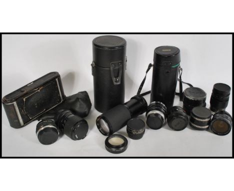 A collection of vintage 20th Century cameras and lenses to include a Kodak folding camera with red leather bellows with leath