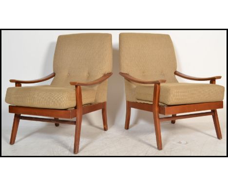 A pair of retro 20th Century open framed teak wood lounge /&nbsp;fireside armchairs each being upholstered with a chintz butt