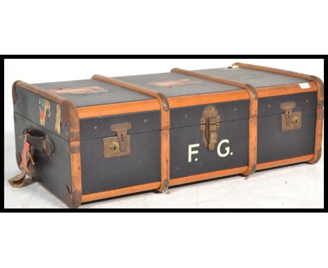 A vintage 20th century blue and canvas bound steamer trunk case having hinged centre with clasps and leather handles to the s