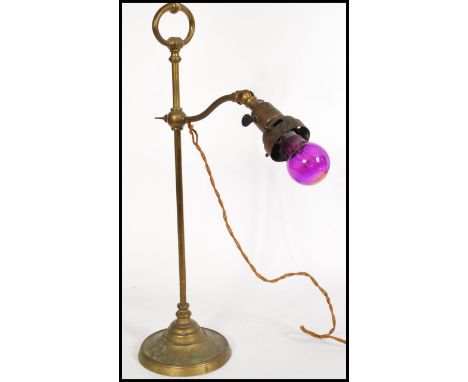 A vintage brass gas lamp converted into an anglepoise lamp with a roped wire, on a circular pedestal base and a handle to the