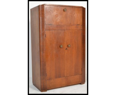 An art deco 1930's stained oak metamorphic cocktail cabinet. The cabinet having a metamorphic action fold drop down door to t