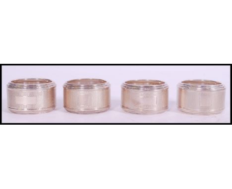 A set of four silver hallmarked engine turned napkin rings, makers marks for&nbsp;Sanders &amp; Mackenzie, Birmingham assay m