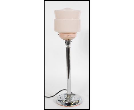 A vintage retro 20th century Art Deco table lamp raised on a circular base with tubular column and pink glass conical and ban
