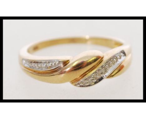 A hallmarked 20th century 9ct gold and diamond ring with a twist design and inset diamonds. Hallmarked Sheffield. Weight 2.2g