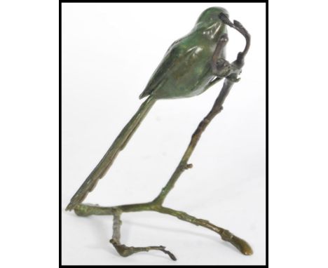 A bronze cold cast figurine of a tit perched on a branch signed by P. A. Northcroft to the base, limited edition number 232/3