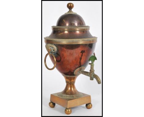A late 19th century Victorian copper and brass Samavar having a finial lid, with twin ram head mask swing handles, having a g