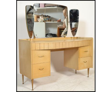A vintage retro 20th century light wood veneer dressing table having a triptych mirror back. The configuration of drawers rai
