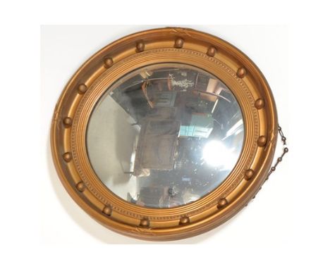 A Regency style gilt circular convex wall mirror, the frame finished in gilt with ball finial detail,