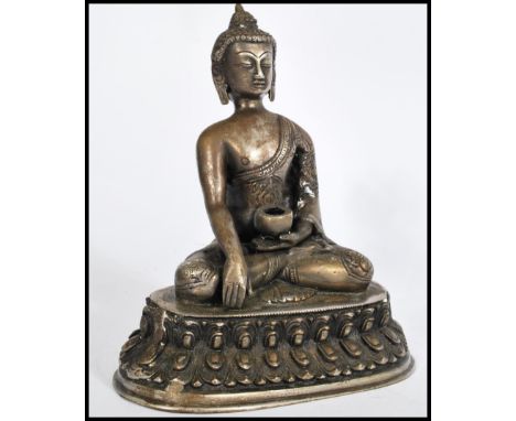 A bronze / brass&nbsp; hollow cast Chinese figurine of a Deity raised on a plinth with detailed edges, the deity sat in lotus